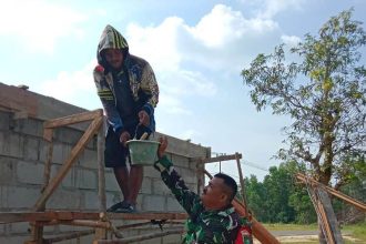 Babinsa Koramil 04/Dabo membantu warga yang sedang membangun rumah.
