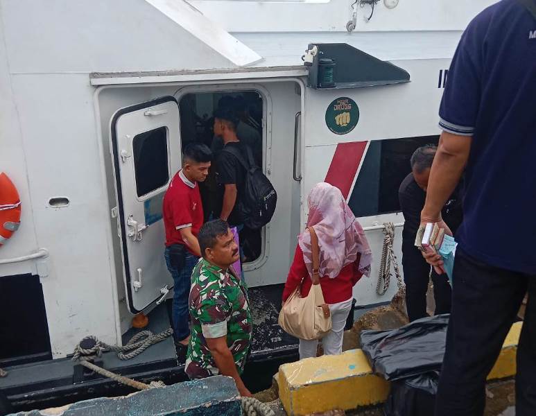 Babinsa Koramil 04/Dabo saat membantu warga yang akan melakukan perjalanan dengan kapal laut.